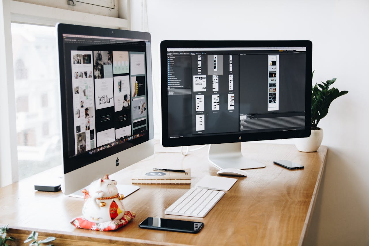 our-story A well-organized design workspace with dual monitors and design software on display.